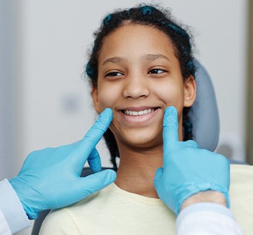 Dentist looking at teen's smile