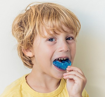 Little boy with blue athletic mouthguard