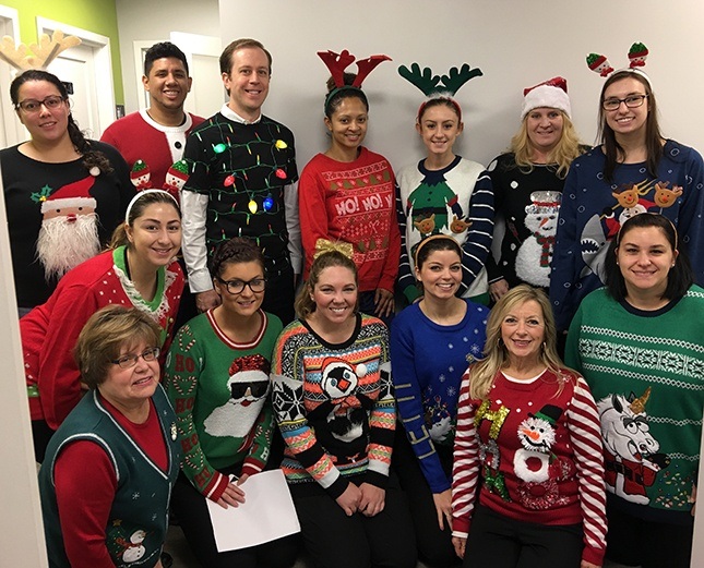 Team members wearing christmas sweaters