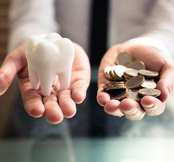 a person holding coins and a model tooth
