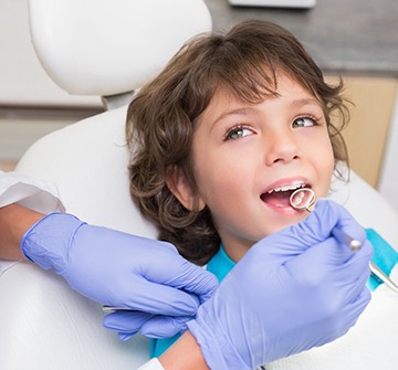 A young child having their teeth checked by a pediatric dentist