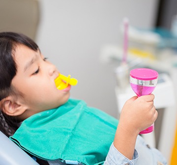 young girl reclined receiving fluoride treatment