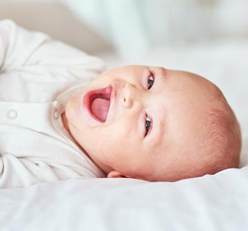 Laughing baby in a bed