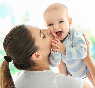 Mother kissing baby on cheek