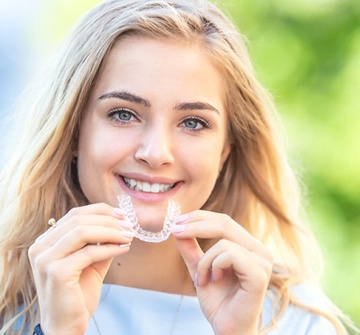 A young girl preparing to reinsert an Invisalign Teen aligner