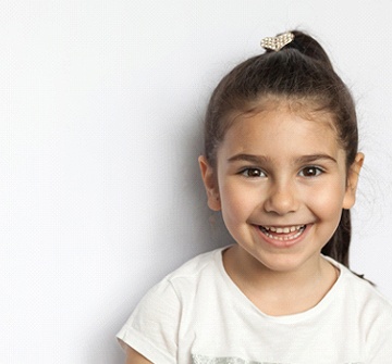 Smiling little girl in front of white background