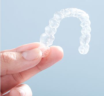 Hand holding clear aligner tray