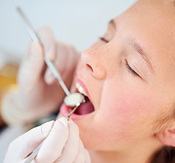 Child with eyes closed during dental exam