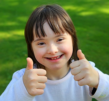 Smiling little girl giving thumbs up