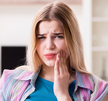 Woman holding cheek in pain