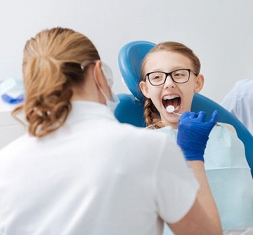 A child performing their routine orthodontic exam.