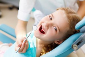 child smiling sitting dentist chair