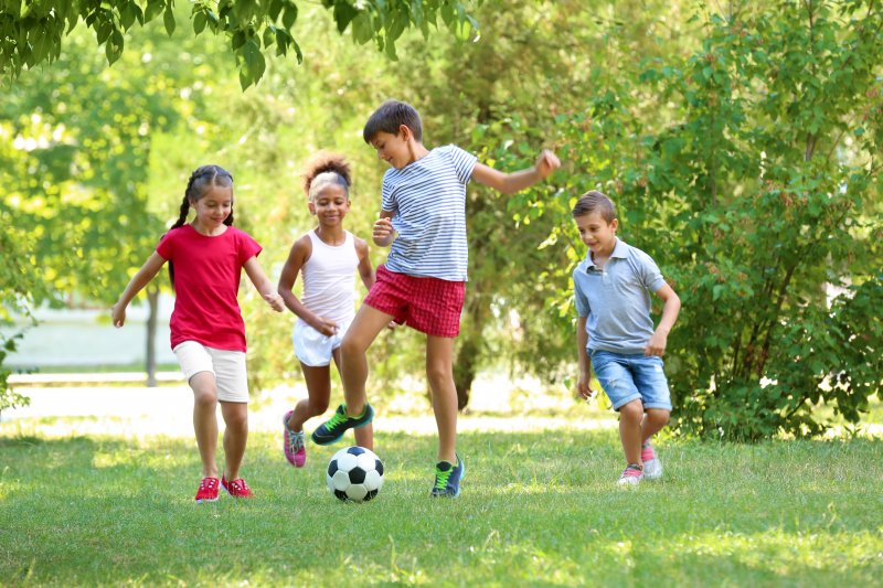 Group of children playing soccer outside