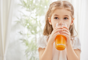 a child drinking orange juice